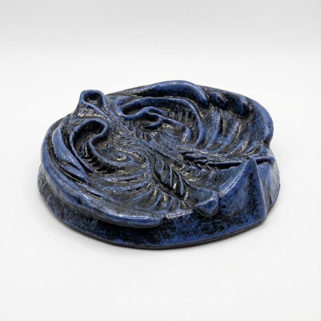 Blue ceramic object with floral design on a white background