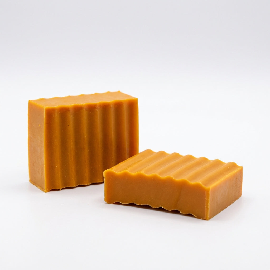 Two rectangular bars of amber-colored soap on a white background
