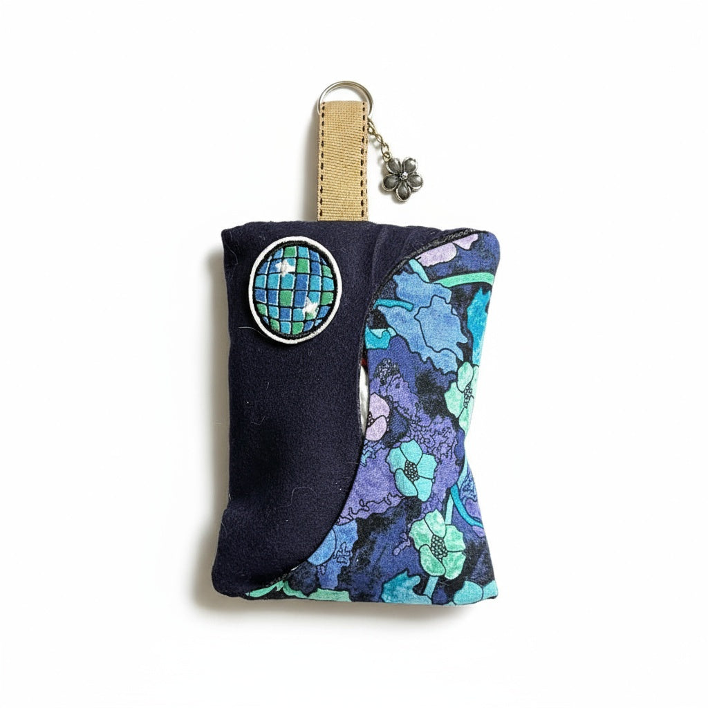 Keychain with floral design and circular emblem on a white background